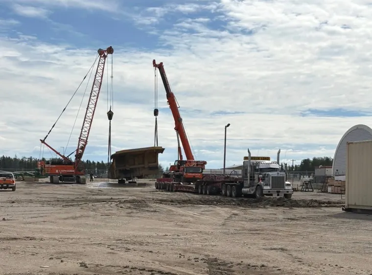 Two cranes setting a load onto the trailer